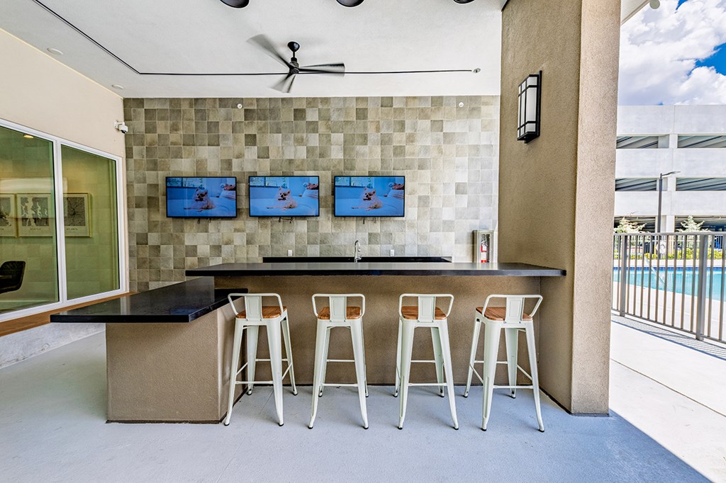 A bar area with four stools and a counter.