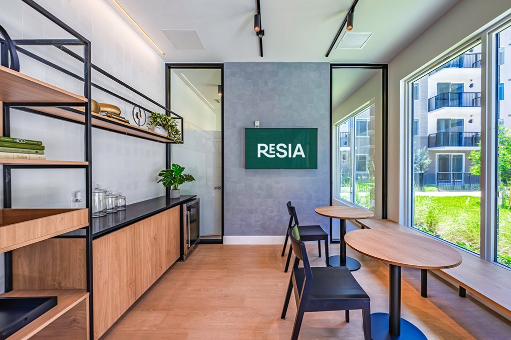 A modern office space with a wooden floor and a green plant on the shelf.