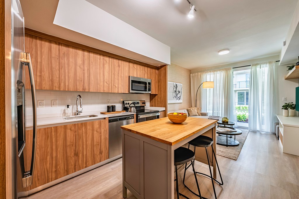 A modern kitchen with wooden cabinets and stainless steel appliances.