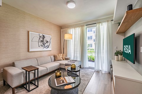 A living room with a sofa, a coffee table, and a painting on the wall.