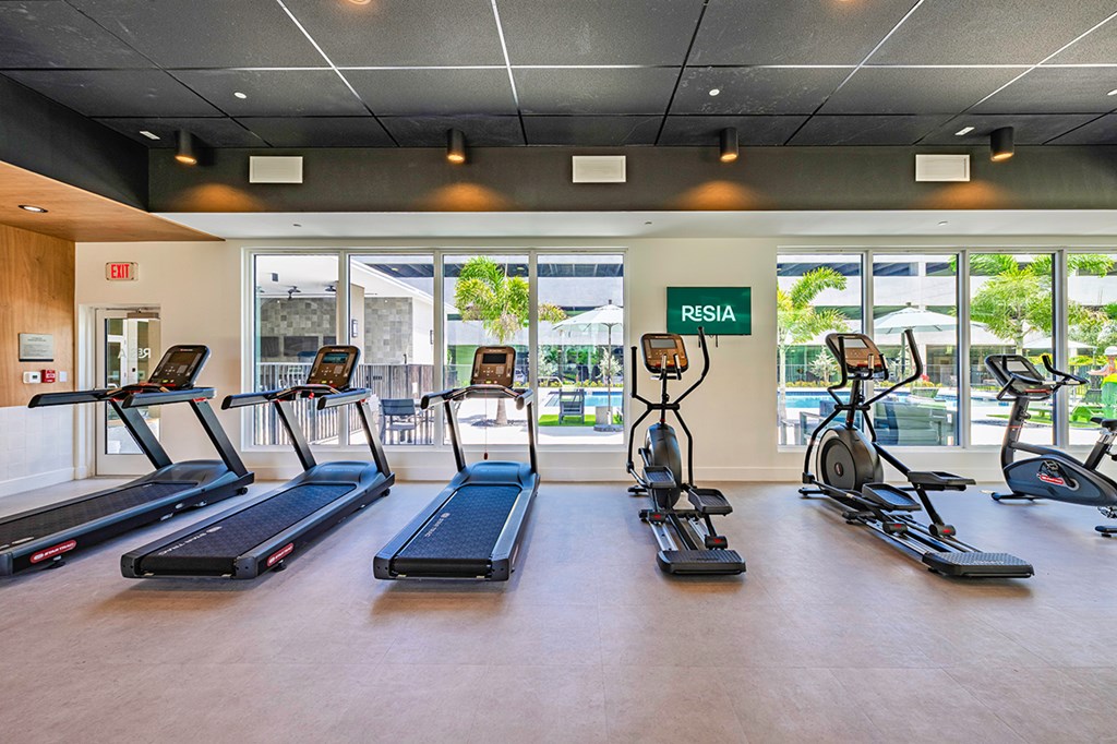 A gym with treadmills and elliptical machines.
