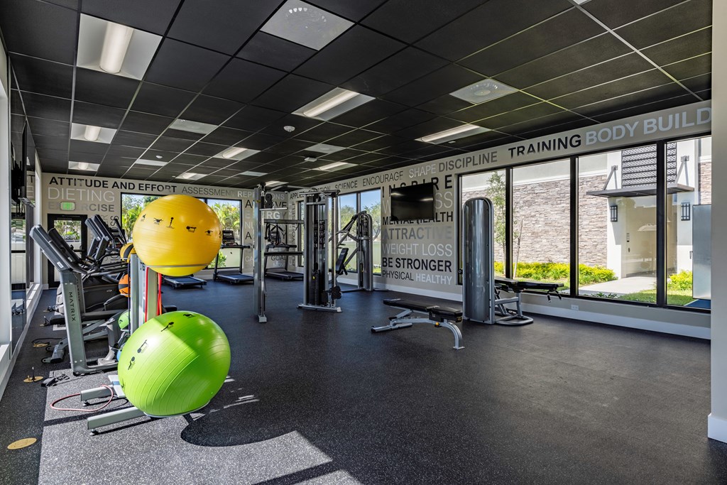 a gym with weights and a yellow ball in the middle of the floor
