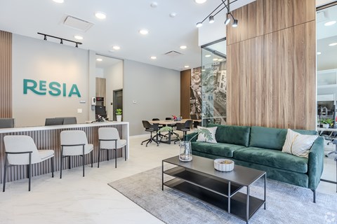 A modern office space with a green sofa and a white desk.
