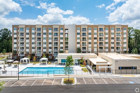 A large building with a pool in front of it.