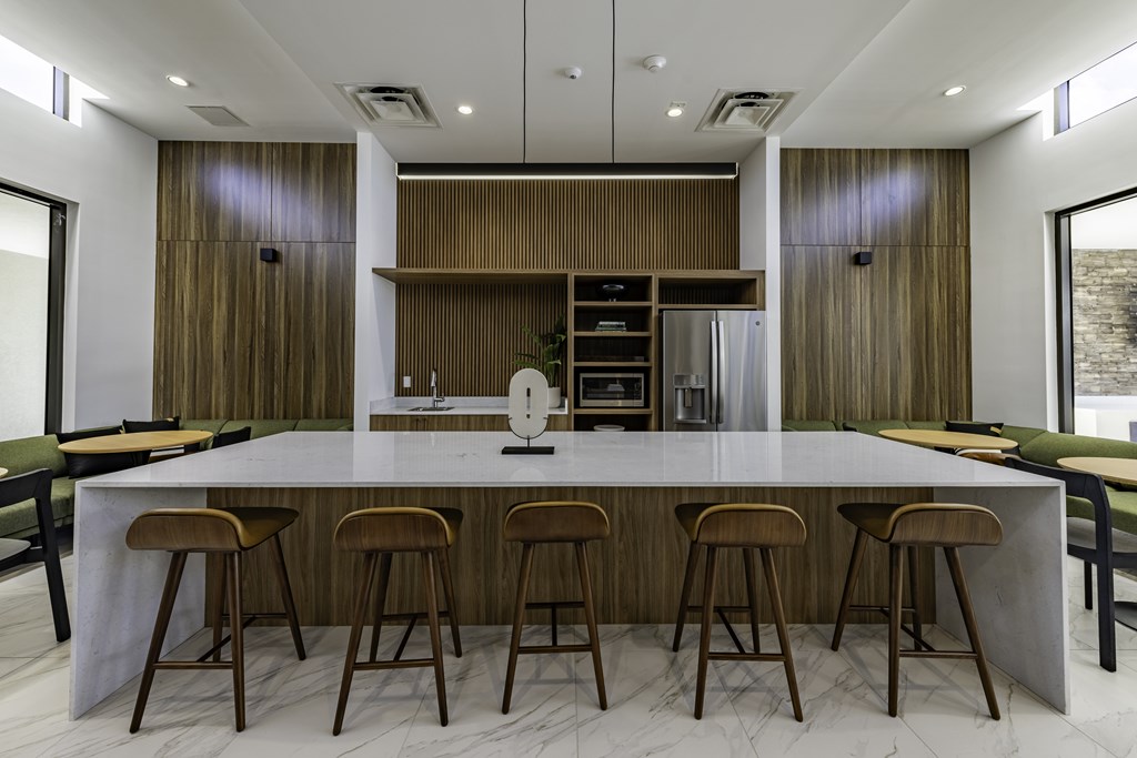 A modern kitchen with a long island and bar stools.