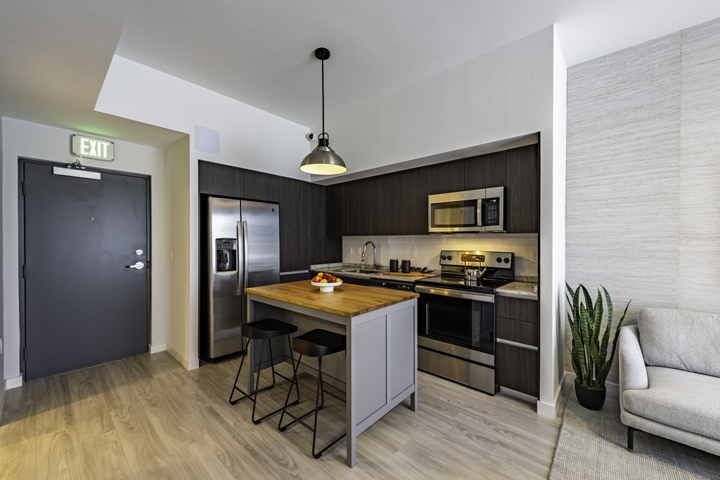A modern kitchen with a breakfast bar and a couch.