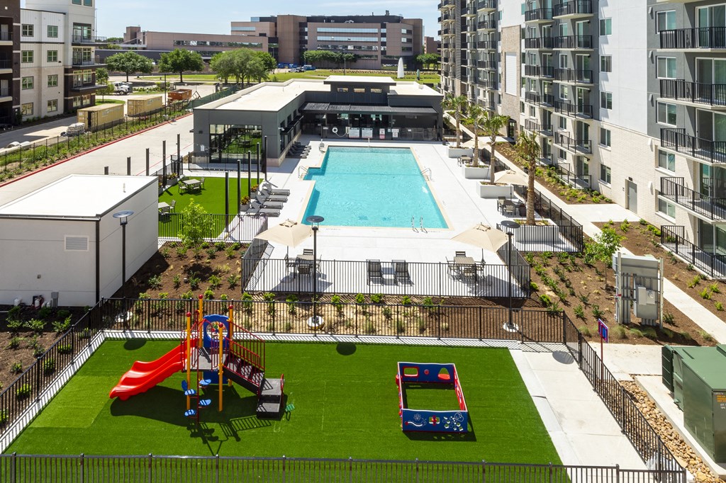 an aerial view of an apartment complex with a swimming pool and a playground