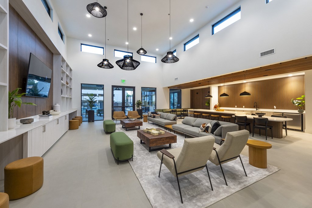 a living room with couches and chairs and a kitchen and a television