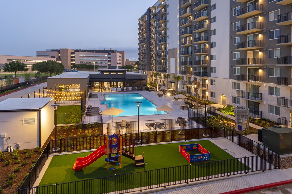 an aerial view of an apartment complex with a pool and playground