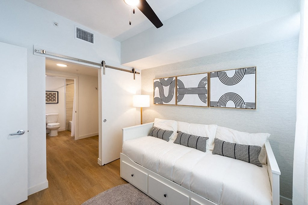 a bedroom with a white bed and a painting on the wall