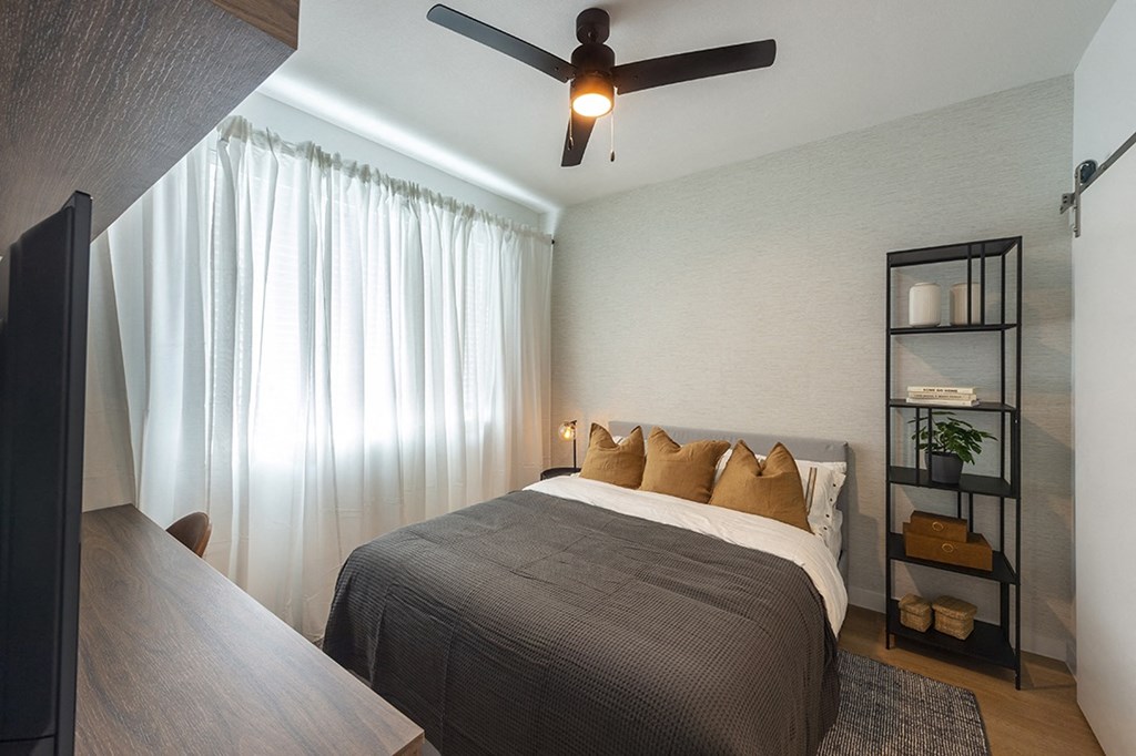 a bedroom with a bed and a ceiling fan