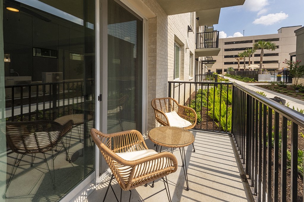 a balcony with wicker chairs and a table on a balcony