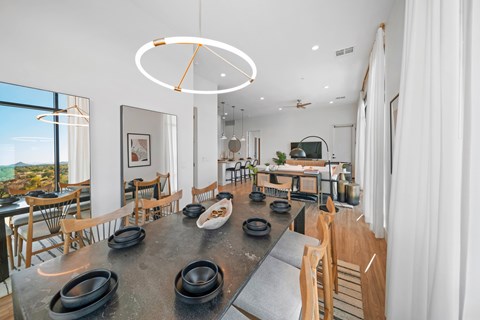 A modern dining room with a large table and chairs.