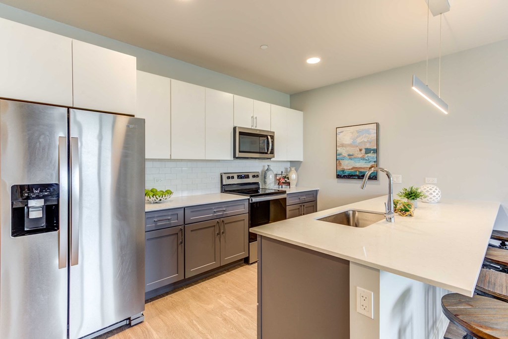 a modern kitchen with white cabinets and stainless steel appliances