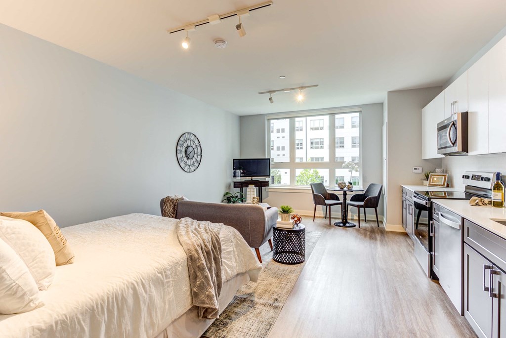 a bedroom with a bed and a chair in front of a window