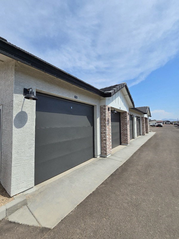 the front of a building with a gray garage door