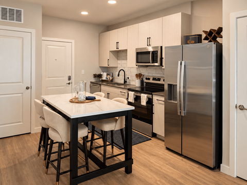 A kitchen with a table and chairs in the middle of it.