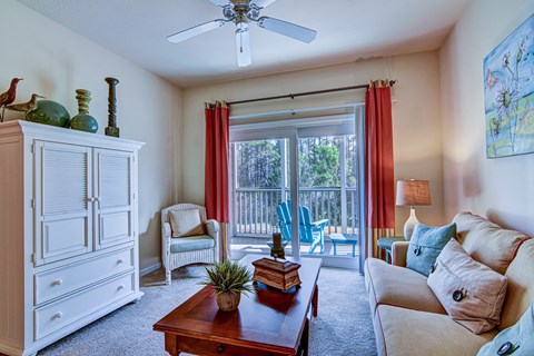 A living room with a white dresser, a wooden coffee table, a white couch, and a painting on the wall.