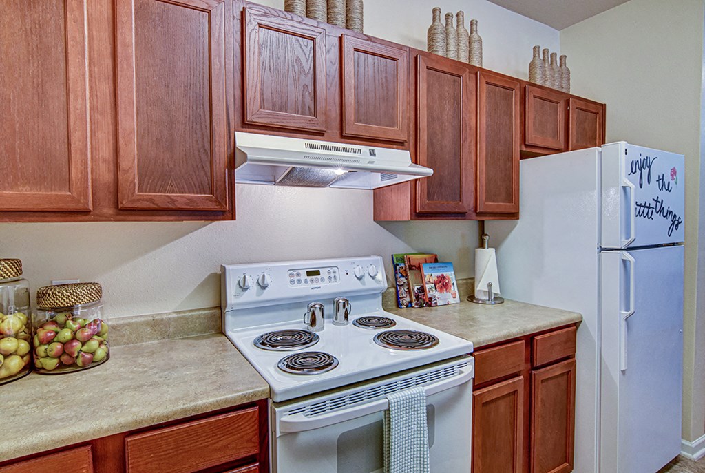 A kitchen with a white stove and a white refrigerator.
