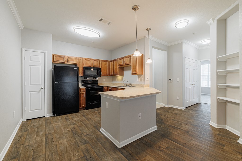 a kitchen with an island and a black refrigerator