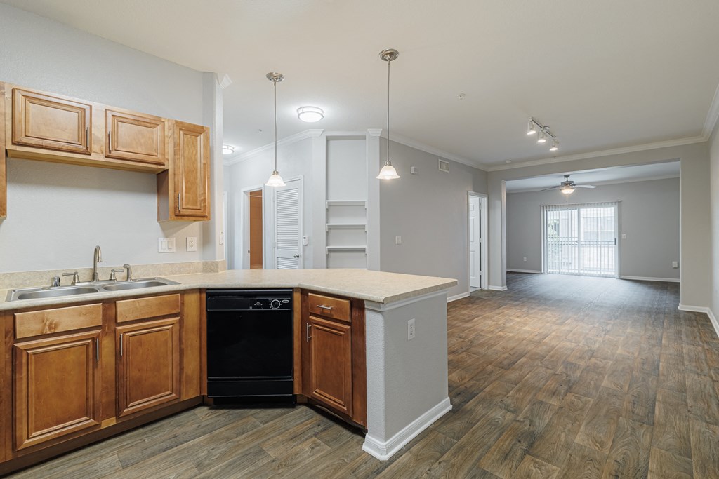 an empty kitchen with wooden cabinets and a black dishwasher