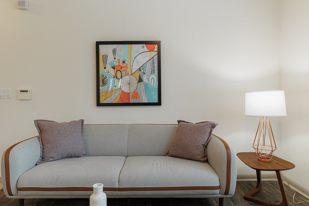 a living room with a couch and a painting on the wall