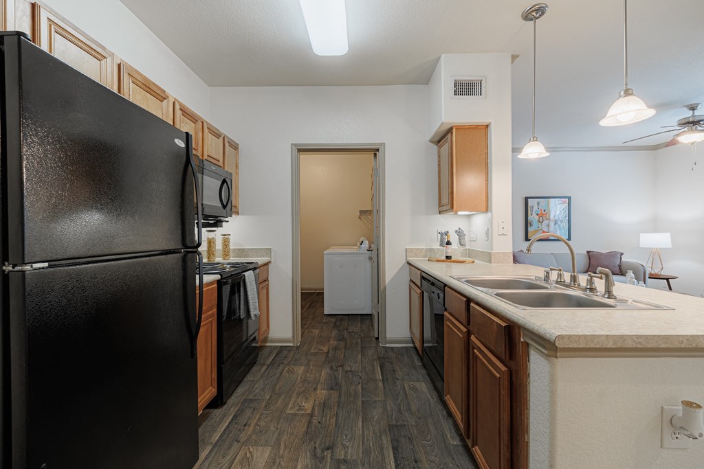 a kitchen with black appliances and a sink and a refrigerator