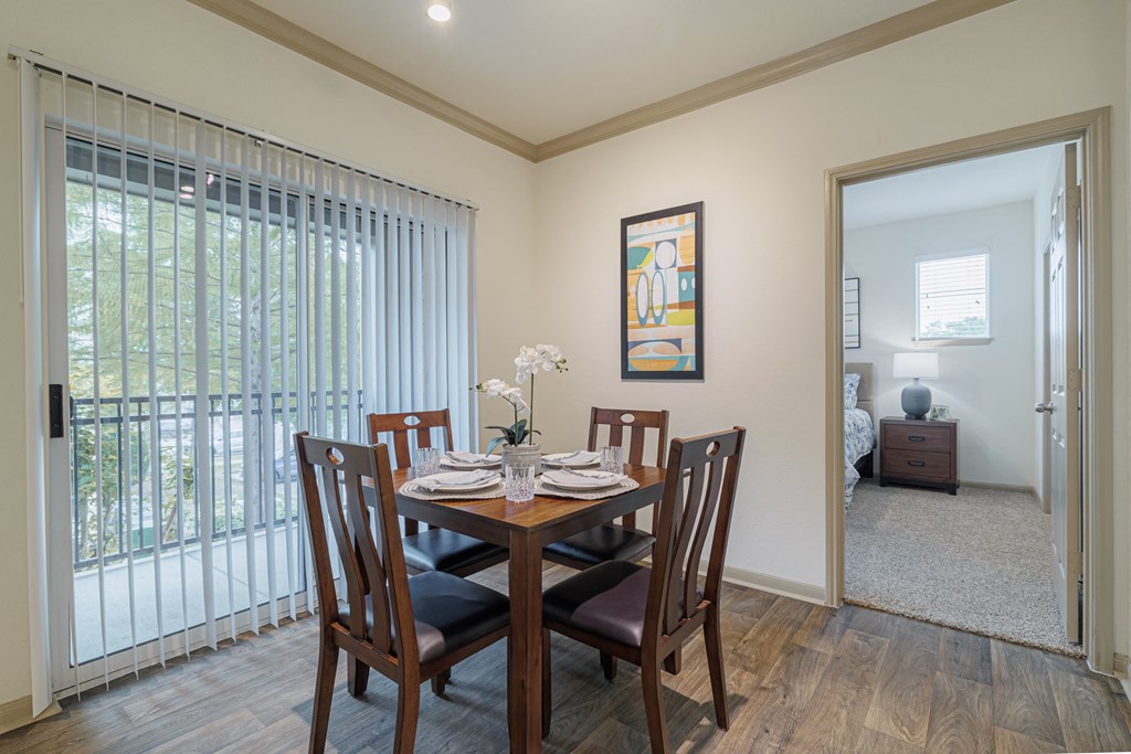 a dining room with a wooden table and chairs and a sliding glass door