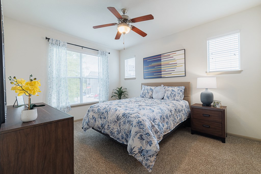 a bedroom with a bed and a ceiling fan