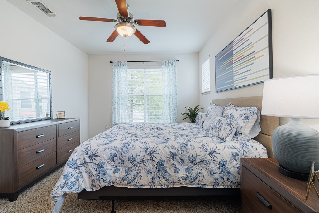 a bedroom with a bed and a ceiling fan