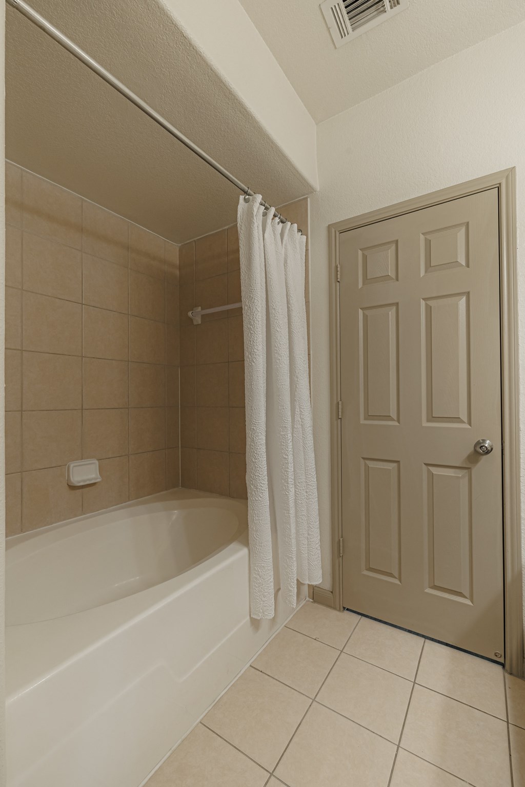 a bathroom with a tub and a shower and a white door