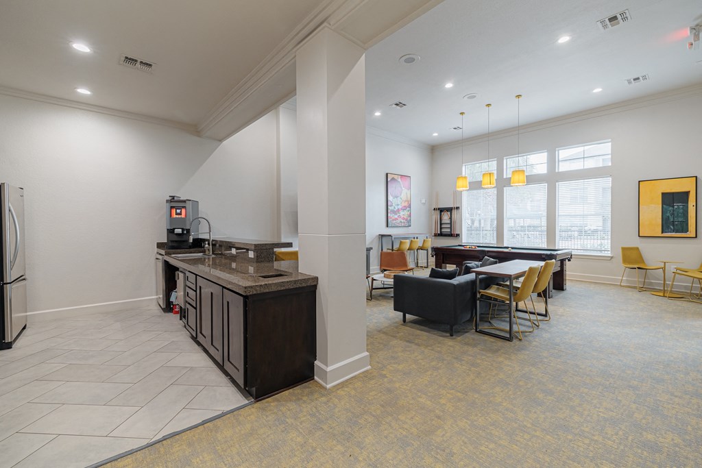 a clubhouse with a kitchen and a dining room with a table and chairs