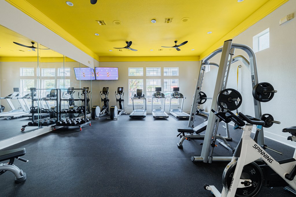 a gym with weights and other exercise equipment and windows