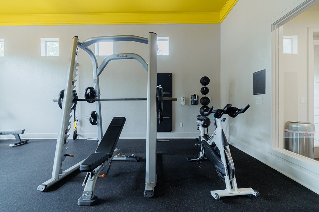 a gym with weights and cardio equipment in a hotel room