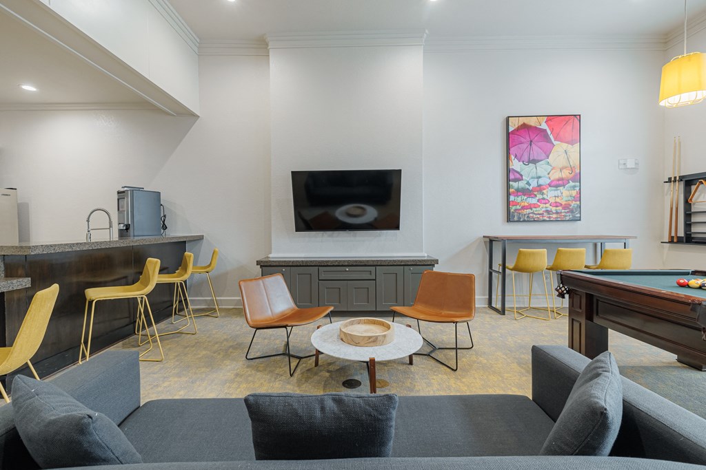 a living room with couches and chairs and a pool table