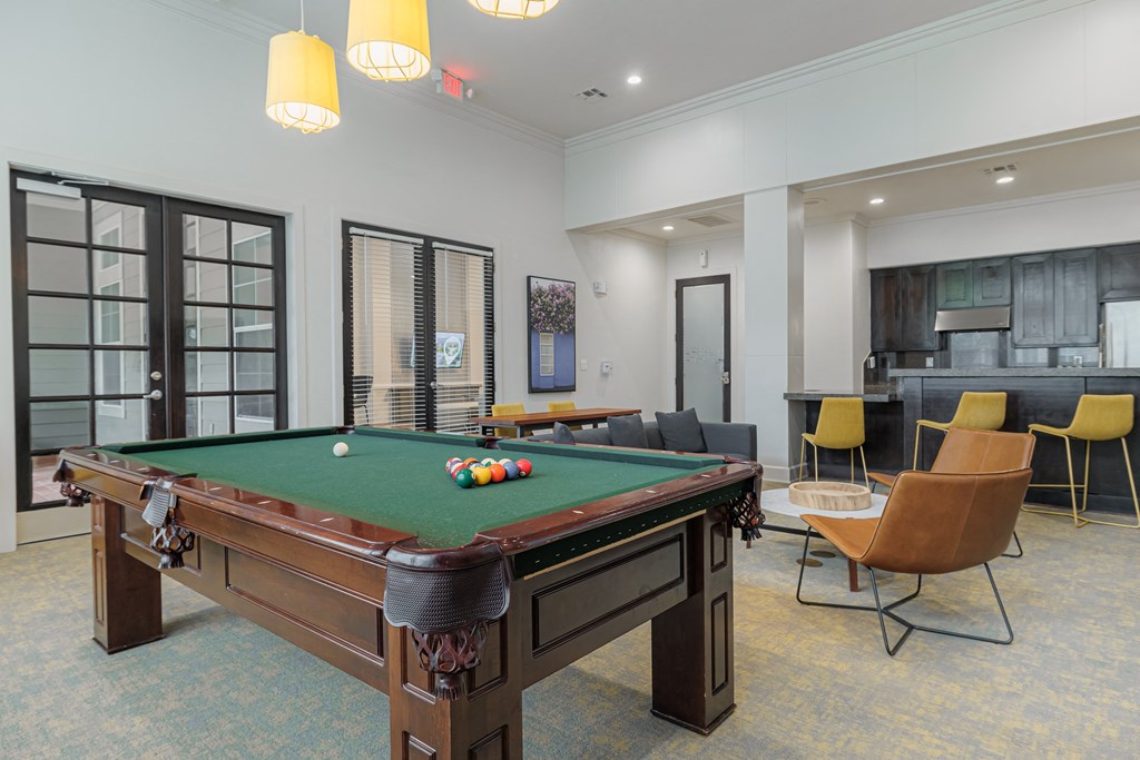 a community room with a pool table and chairs