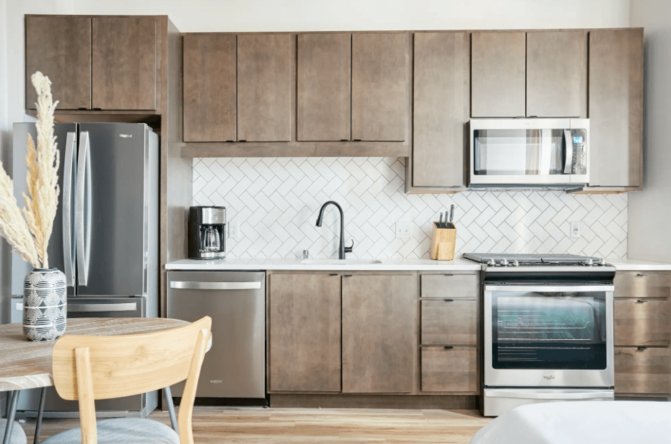 a kitchen with wooden cabinets and stainless steel appliances and a table