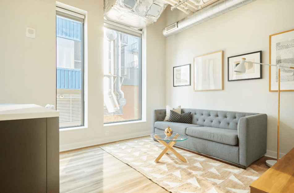 a living room with a couch and a table     and a window