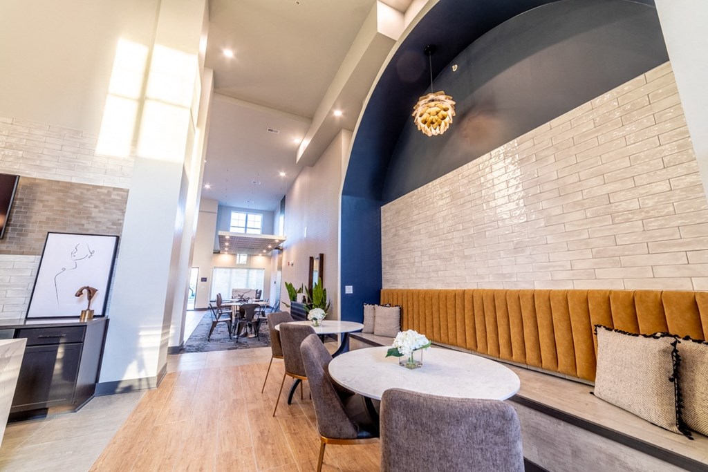 a lobby with tables and chairs and a brick wall