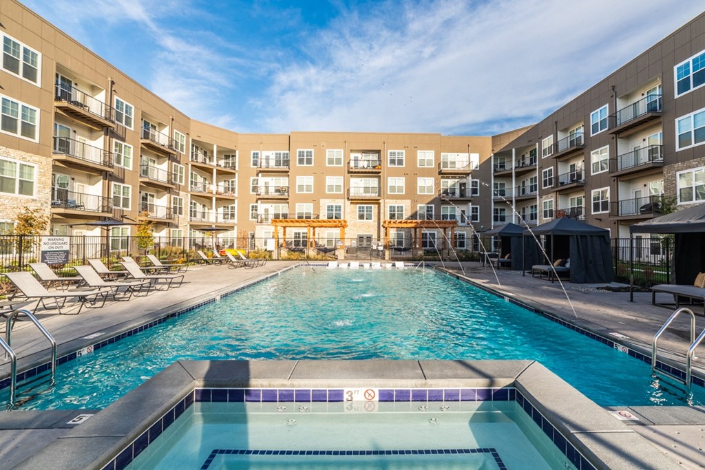 a swimming pool with an apartment building in the background