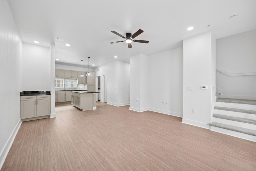 A spacious room with a ceiling fan and lighting fixtures.