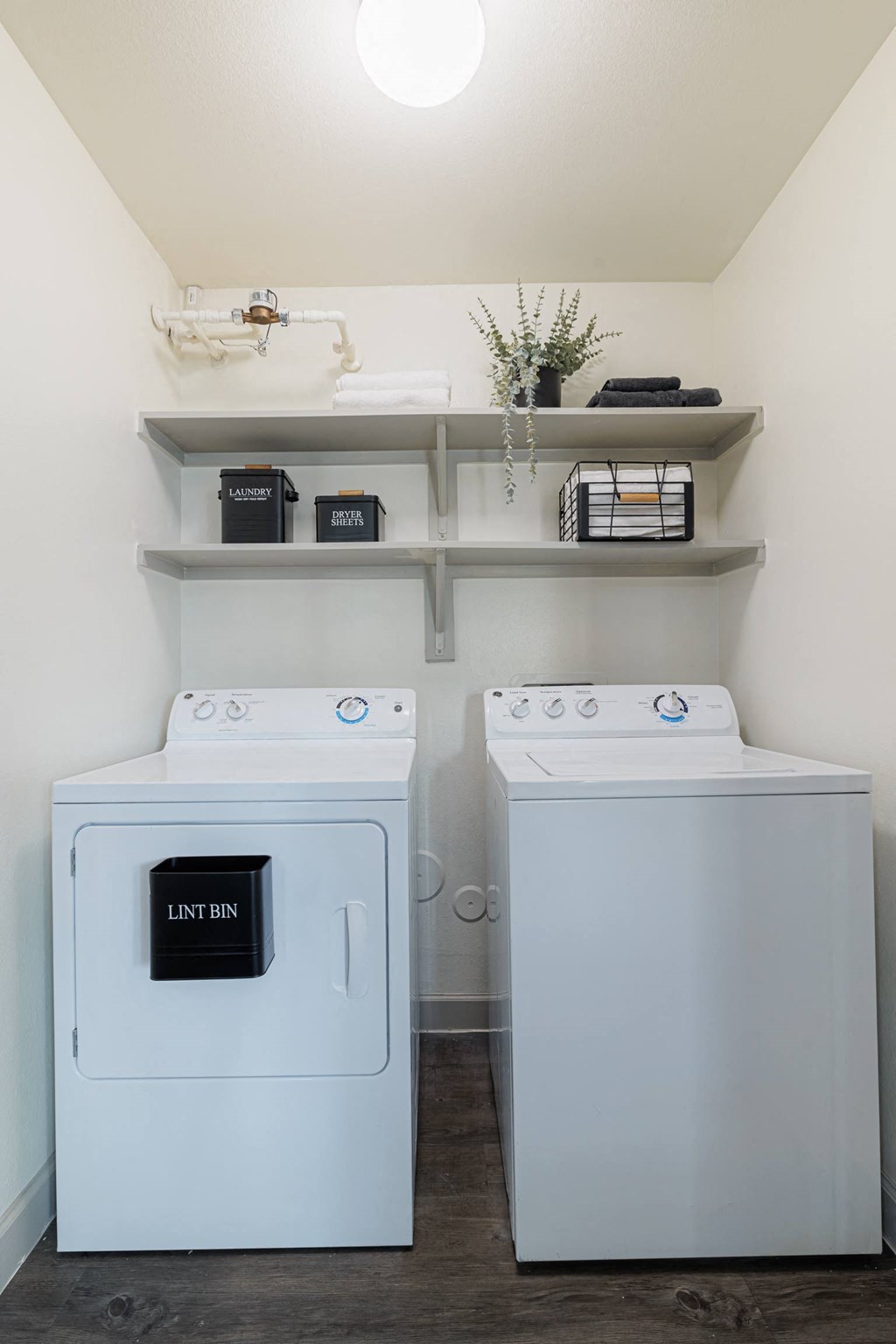 a washer and dryer in a laundry room with shelves