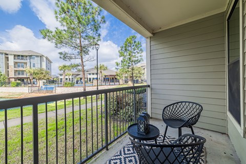 a patio with two chairs and a table on a balcony