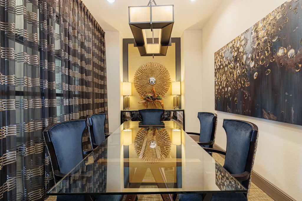 a dining room with a long glass table and blue chairs