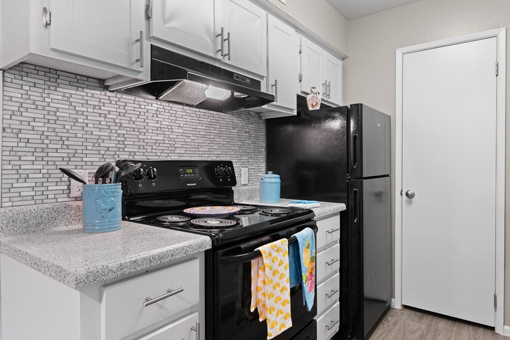 A black stove top oven with a blue container on the counter.