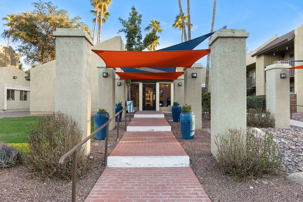 A pathway with a red roof and pillars on either side.