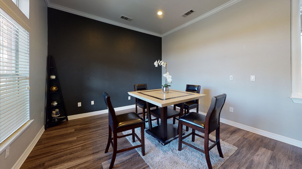 a dining room with a table and chairs and a large window