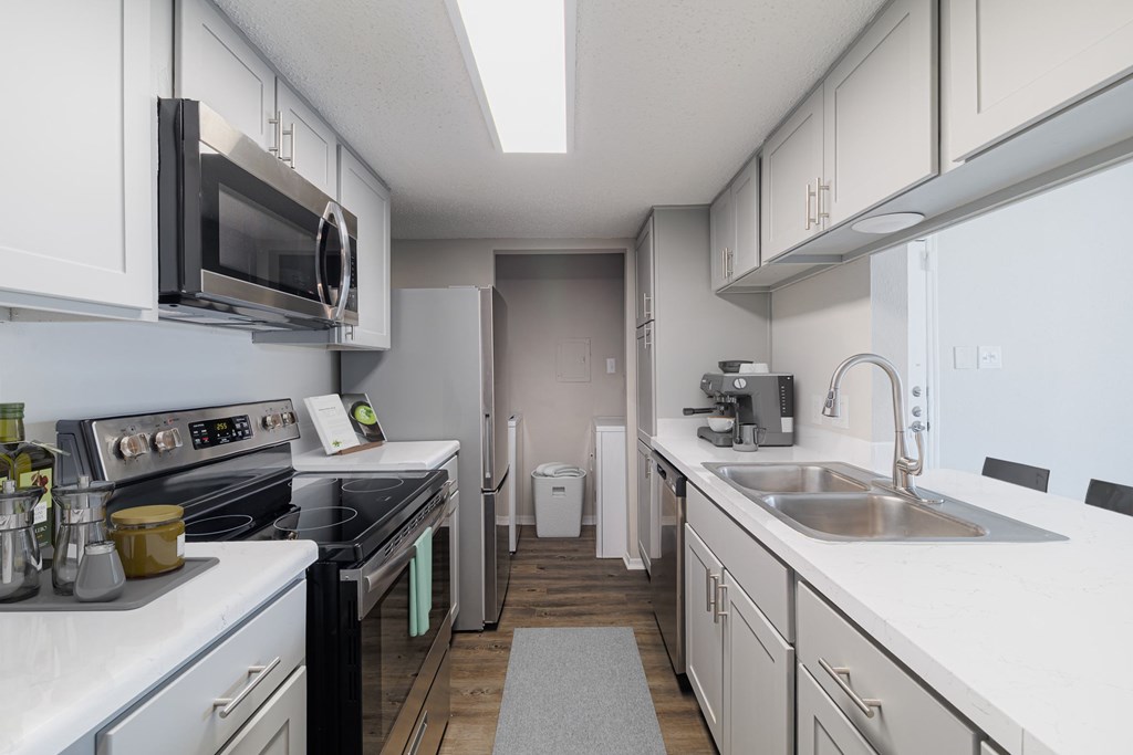 A kitchen with white cabinets and appliances.