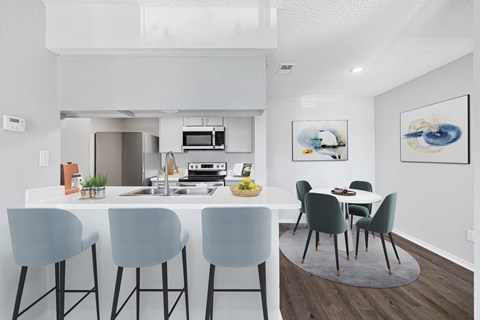 A modern kitchen with a dining table and chairs.