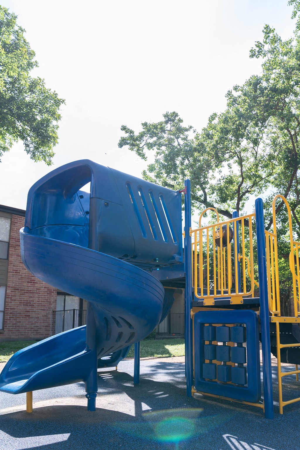 a playground with a blue slide and a yellow slide